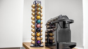 Une machine à café et un distributeur de boissons en conserve sont posés sur un comptoir en bois.
