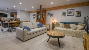 Una sala de estar moderna con un sofá, una mesa de centro y un comedor con sillas y una mesa.