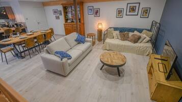 Uma sala de estar moderna com sofá, mesa de centro e área de jantar.
