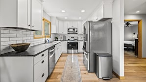 A modern kitchen with white cabinets, stainless steel appliances, and a wooden floor. - High Top: AMAZING views on a private 100 acres within city limits: EXCLUSIVE! (Sevierville)