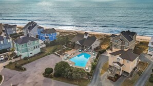An aerial view of a coastal residential area with houses, a swimming pool, and a beach. - Oceanfront home w/ Backyard Beach Access! (North Topsail Beach)