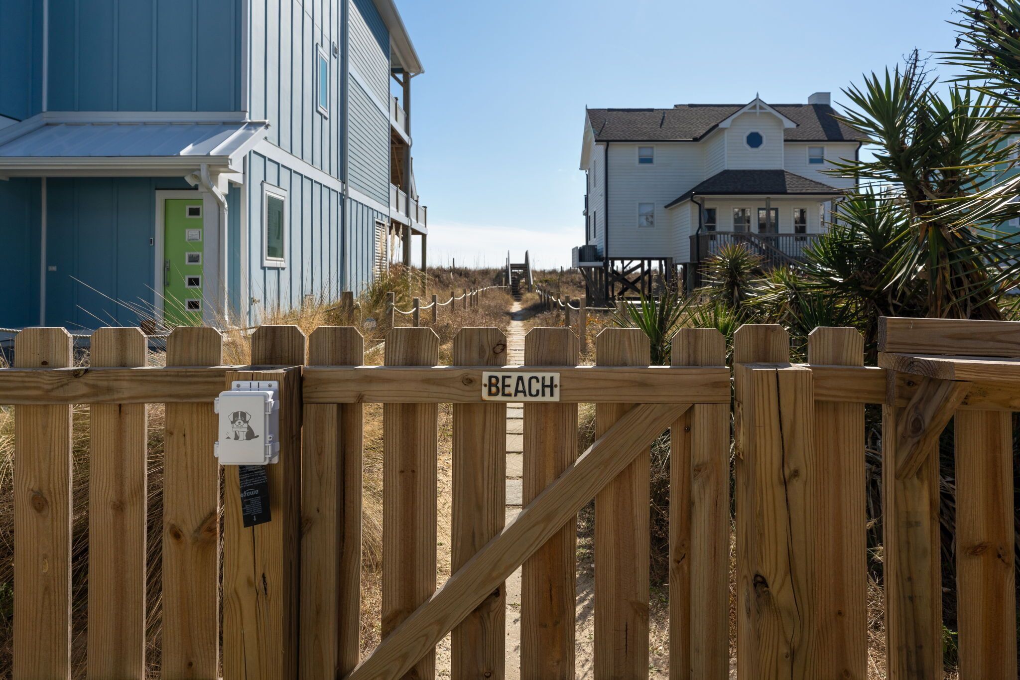 A wooden beach gate with a sign reading "BEACH".