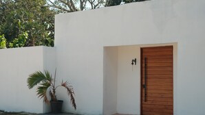 A white building with a wooden door and a potted plant. - Hanna suite  (Catemaco)