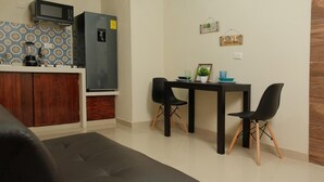 A compact living space with a kitchenette, a dining area with two chairs, and a sofa. - Hanna suite  (Catemaco)