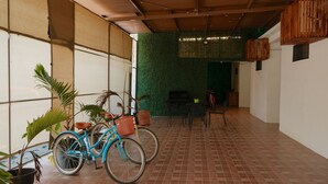 A covered patio area with a tiled floor, a blue bicycle, and potted plants. - Hanna suite  (Catemaco)