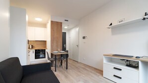 A modern apartment with a living room, a dining area, a kitchenette, and a workspace. - SMART studio w/1GB speed WiFi + Monitor | A/C | Onsite Free Parking Spot (Praha 5)