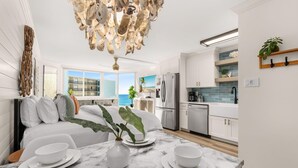 A modern kitchen with white cabinets, a marble countertop, and a view of the ocean. - Stylish Boho Studio for 4 | Top of the Gulf Resort (Panama City Beach)