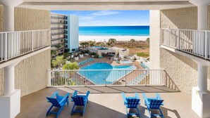A balcony with a view of a beach and a pool area. - Stylish Boho Studio for 4 | Top of the Gulf Resort (Panama City Beach)