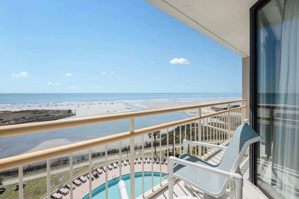 A balcony with a pool, lounge chairs, and a view of the beach and ocean. - 3BR Pools, Direct Ocean Front, Ocean Creek, Views! (Myrtle Beach)