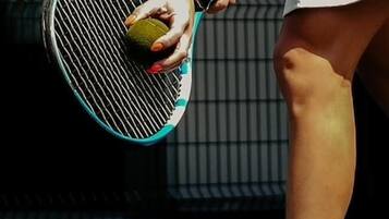 A tennis racket and ball, a white shirt, and white sneakers.