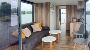 Un intérieur moderne avec un canapé, deux petites tables et une chaise.