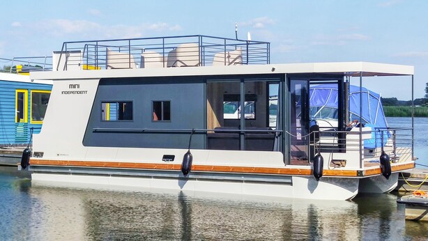Un bateau blanc doté d’un pont supérieur couvert, de fenêtres et d’un espace cabine.
