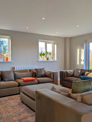 A modern living room with two sofas, a coffee table, and a patterned rug.