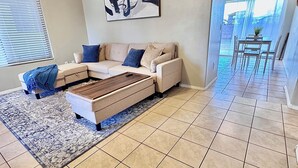 A modern living room with a sofa, a coffee table, a rug, and a painting on the wall. - new listing (Phoenix)