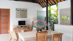 Une cuisine moderne dotée d’un grand îlot central, de meubles en bois et d’un téléviseur à écran plat.