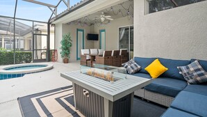 Eine überdachte Terrasse im Freien mit Pool, Feuerstelle und Sitzbereich inklusive Sofa und Sesseln.