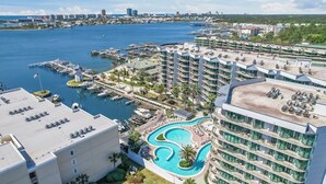 Ein Resort mit einer Marina, mehreren Schwimmbecken und Blick auf die Stadtlandschaft.