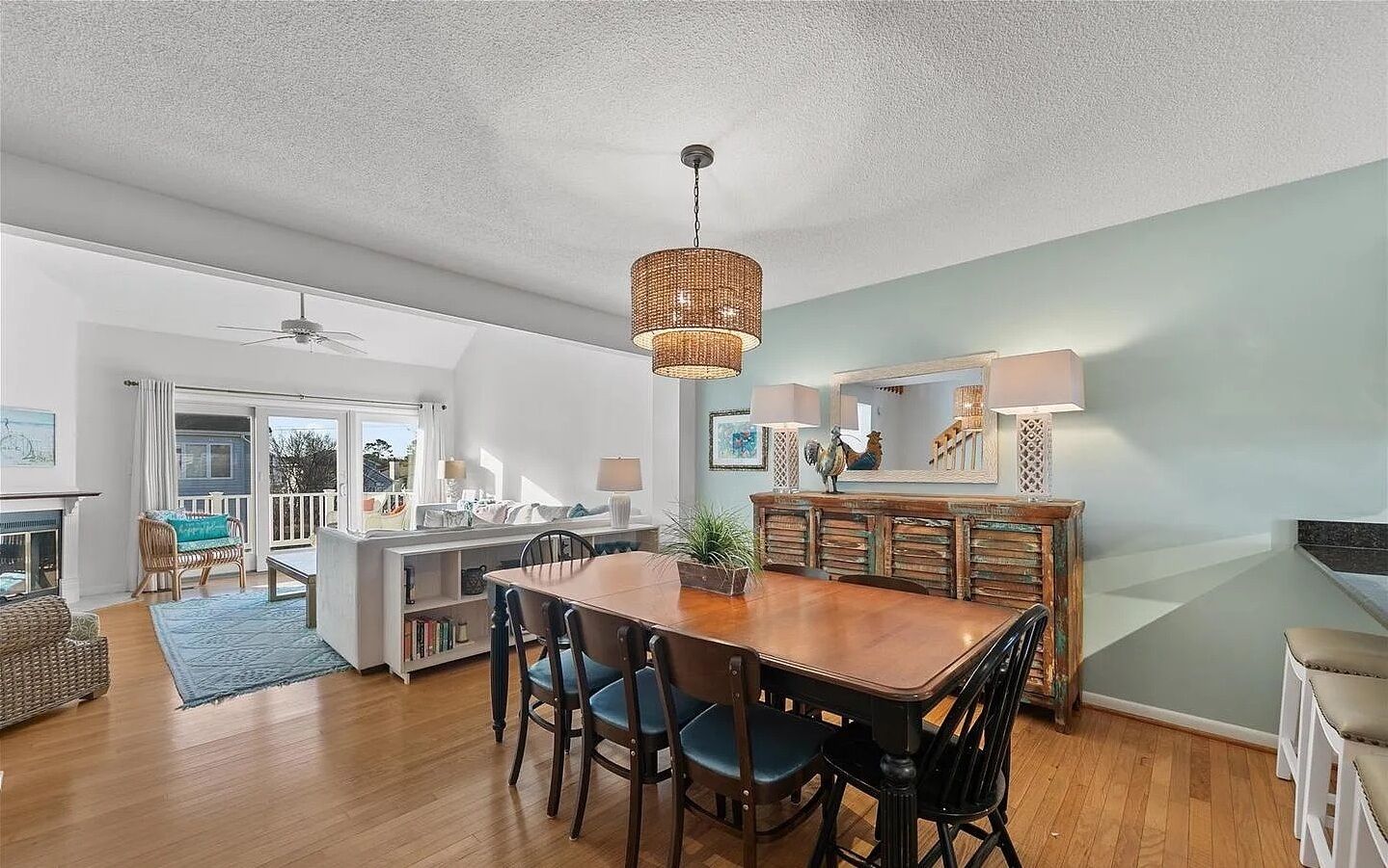 A spacious living area with a dining table, chairs, a sofa, and a fireplace.