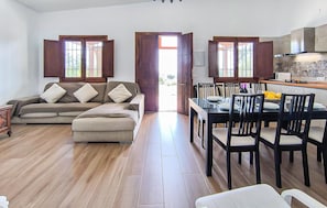 A living room with a sofa and a dining area with a table and chairs.