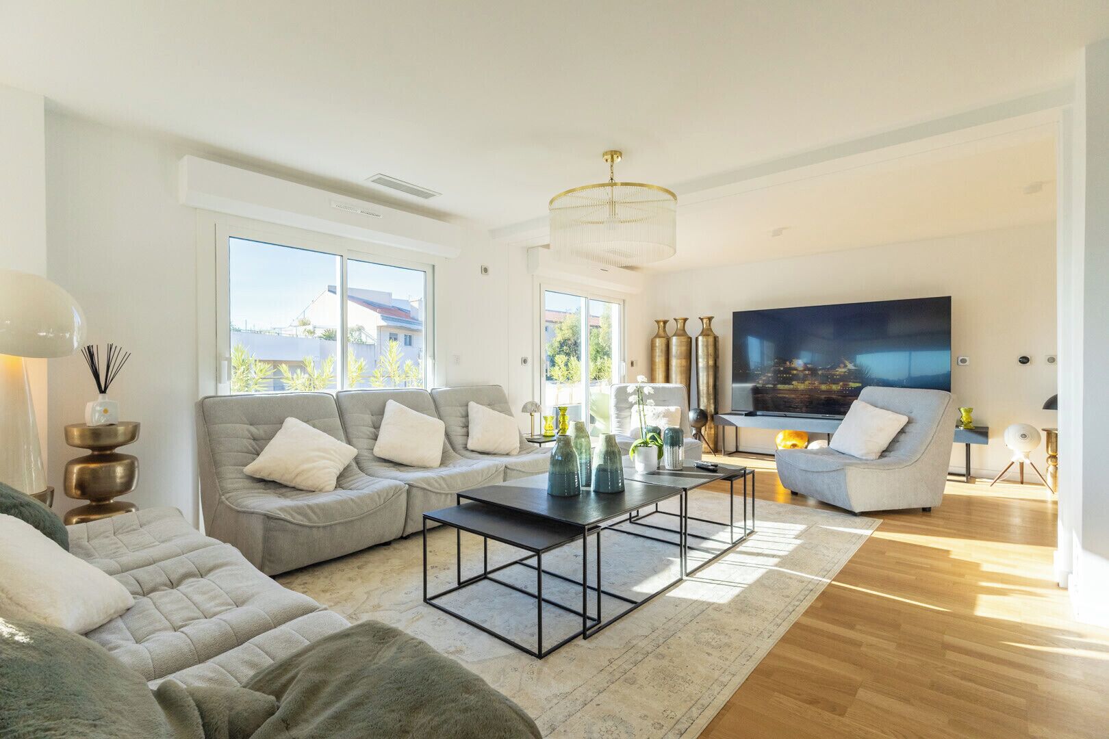 A modern living room with a grey sofa, a coffee table, and a TV.