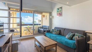 Un salon moderne comprenant un canapé, une table basse et un coin repas avec une table et des chaises.