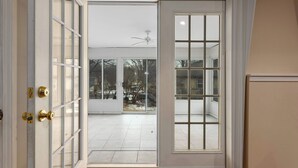 A room with a sliding glass door leading to a balcony with a tiled floor and a ceiling fan. - Spacious Home_2 Living Rooms_Sleeps 14_7 KingBeds (Overland Park)