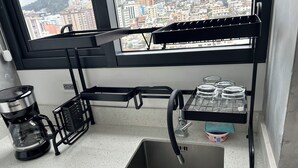 A kitchen with a built-in sink, a coffee maker, and a window with a city view. - Luxury suite in quito (Quito)