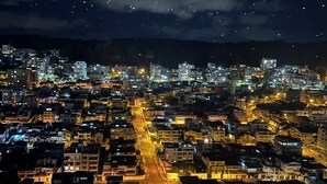 A nighttime aerial view of a densely populated urban area with illuminated buildings and streets. - Luxury suite in quito (Quito)