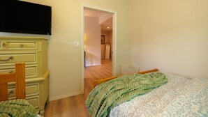 A bedroom with a bed, a dresser, and a television.