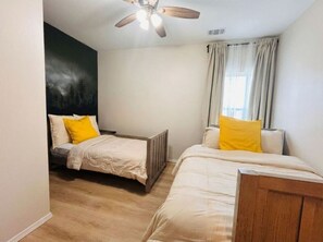 A bedroom with two beds, a ceiling fan, and a window with curtains. - Modern Kitchen•3BR BSMT•Priv back Entry•Near Lake (Acworth)