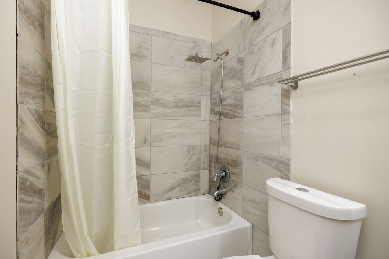 A bathroom with a bathtub, a shower, and a toilet.
