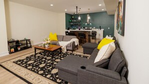 A modern living room with a sofa, coffee table, and a dining area with chairs.