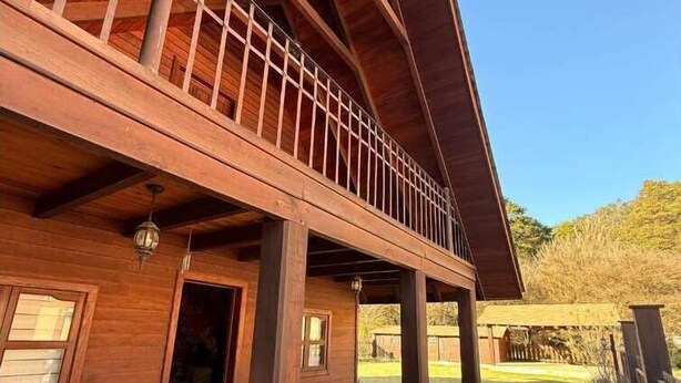 Un bâtiment en bois doté d’un balcon et d’une terrasse couverte.
