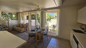 Una habitación amplia con comedor, cocina y grandes puertas correderas de vidrio que dan a un balcón.
