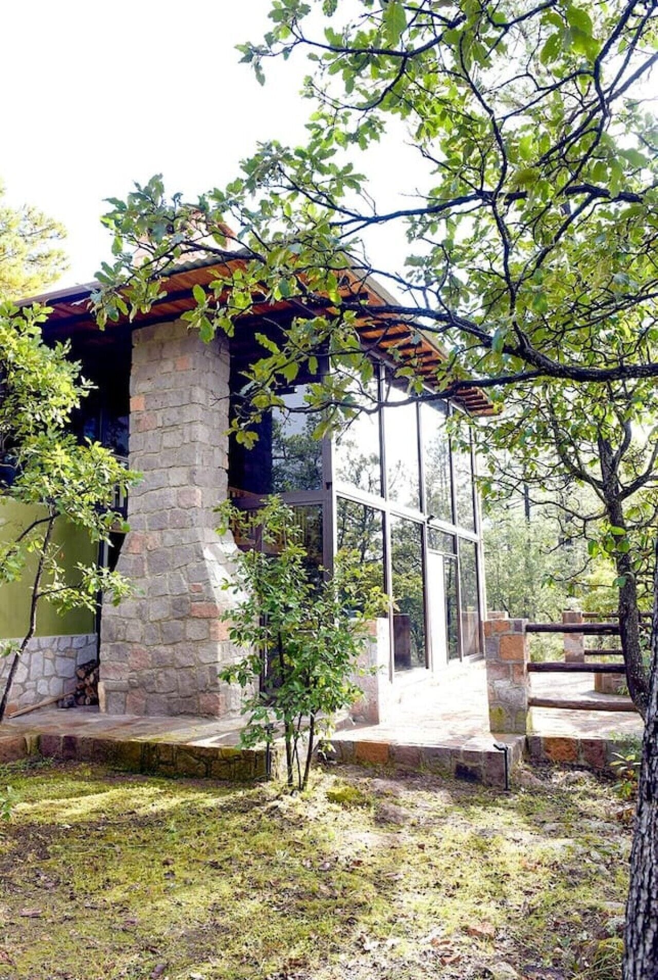 Ein Steinhaus mit Glastür und einer kleinen Veranda.