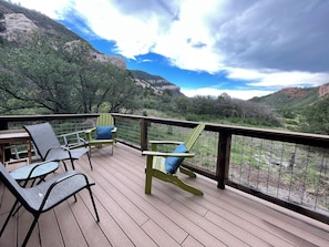 Eine Terrasse mit Sitzgelegenheit und Blick auf eine gebirgige Landschaft.