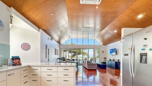 Uma cozinha espaçosa com uma ilha grande, soalho em madeira e vista para o exterior.