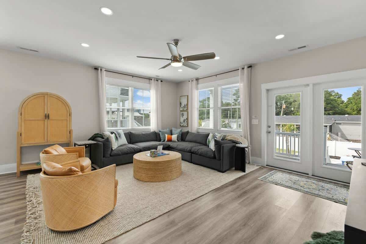 A modern living room with a sectional sofa, a round coffee table, and a ceiling fan.