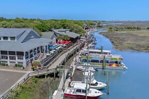 Un restaurante frente al agua, con terraza y barcos amarrados cerca.