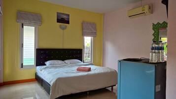 Un dormitorio con cama, un refrigerador azul y ventana con vistas.