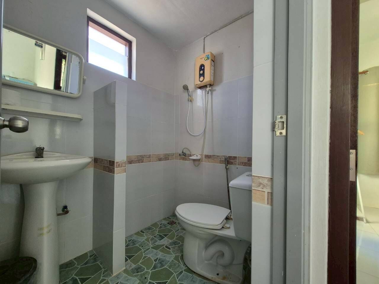 Un baño pequeño con inodoro, lavamanos y ducha.