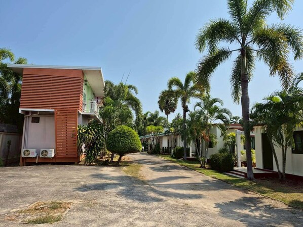 A residential street with houses, palm trees, and a clear sky. - Sam roi yot Sea sight Resort (Sam Roi Yot)
