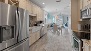 A modern kitchen with stainless steel appliances, light-colored cabinetry, and a central island.
