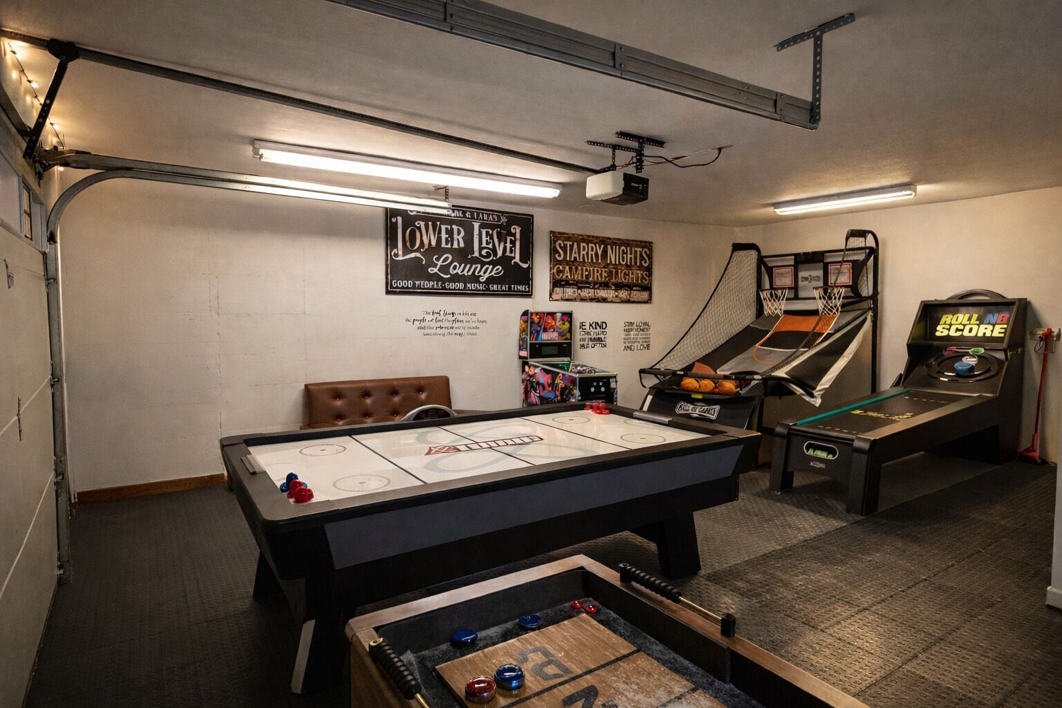 A room with a foosball table, a pool table, and a table tennis table.
