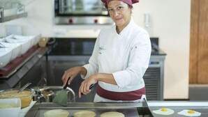 En kock i ett professionellt kök som tillagar mat på en stekhäll.