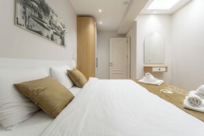 A hotel room with a neatly made bed, a large mirror, and a painting on the wall. - New Eco Flat near Cevahir Mall, Şişli (ist)