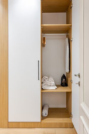 A wardrobe with multiple shelves, a hanging rod, and a door with a handle. - New Eco Flat near Cevahir Mall, Şişli (ist)