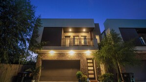 A two-story house with a garage, a balcony, and a brick facade. - 3-bedroom house in nice Houston with cool AC for relaxing stay (Houston)