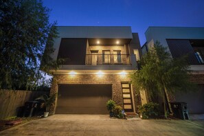 Ein zweistöckiges Haus mit Garage, Balkon und Ziegelverblendung.