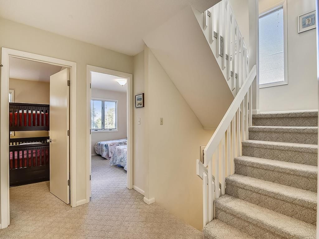 A staircase leading to a bedroom with a bed and a closet.
